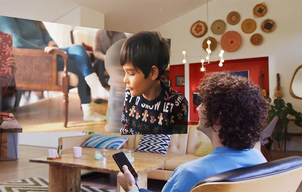 Vīrietis skatās filmu viesistabā, izmantojot XR brilles