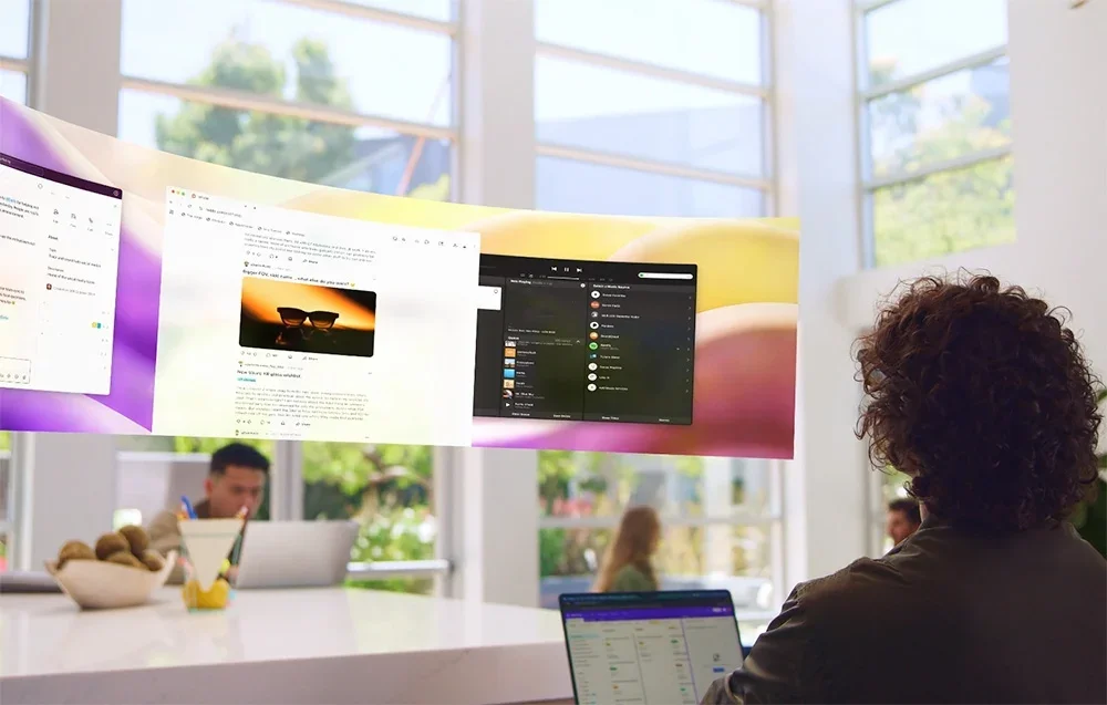 Cilvēks skatās uz virtuāliem ekrāniem ar XR brillēm gaišā istabā
